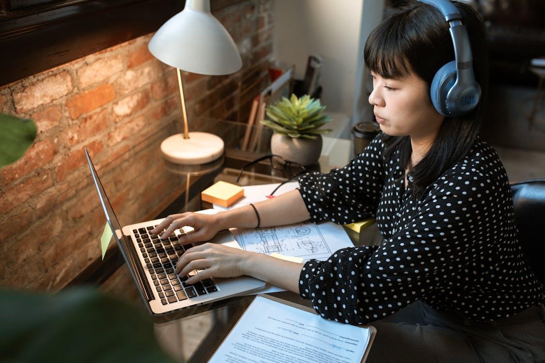 Free Woman in Black and White Polka Dot Long Sleeve Shirt Using Macbook Air Stock Photo