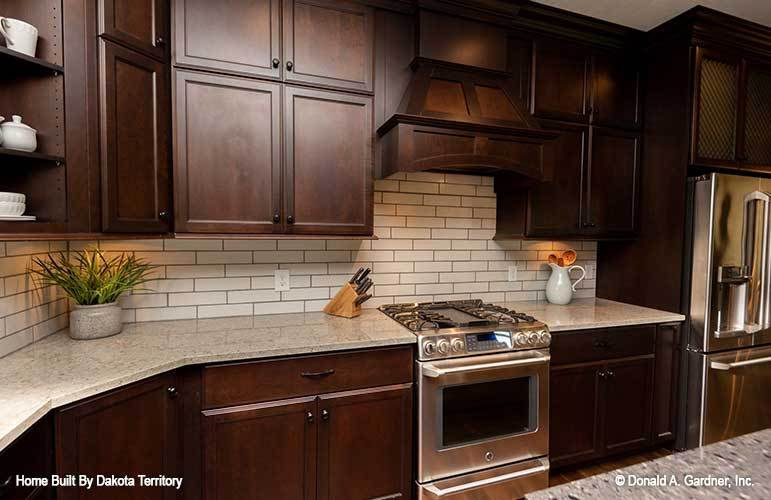 White subway tile backsplash sets a nice accent to the dark kitchen.