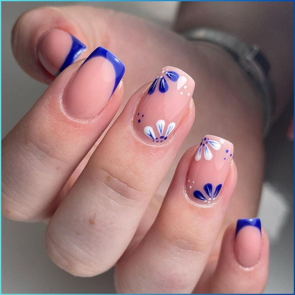 Close up of hands with flowered designed blue nails having Navy with Flowers with French tips