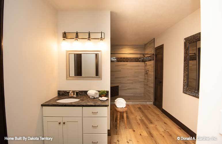 This bathroom has a walk-in shower and a sink vanity paired with a framed mirror.