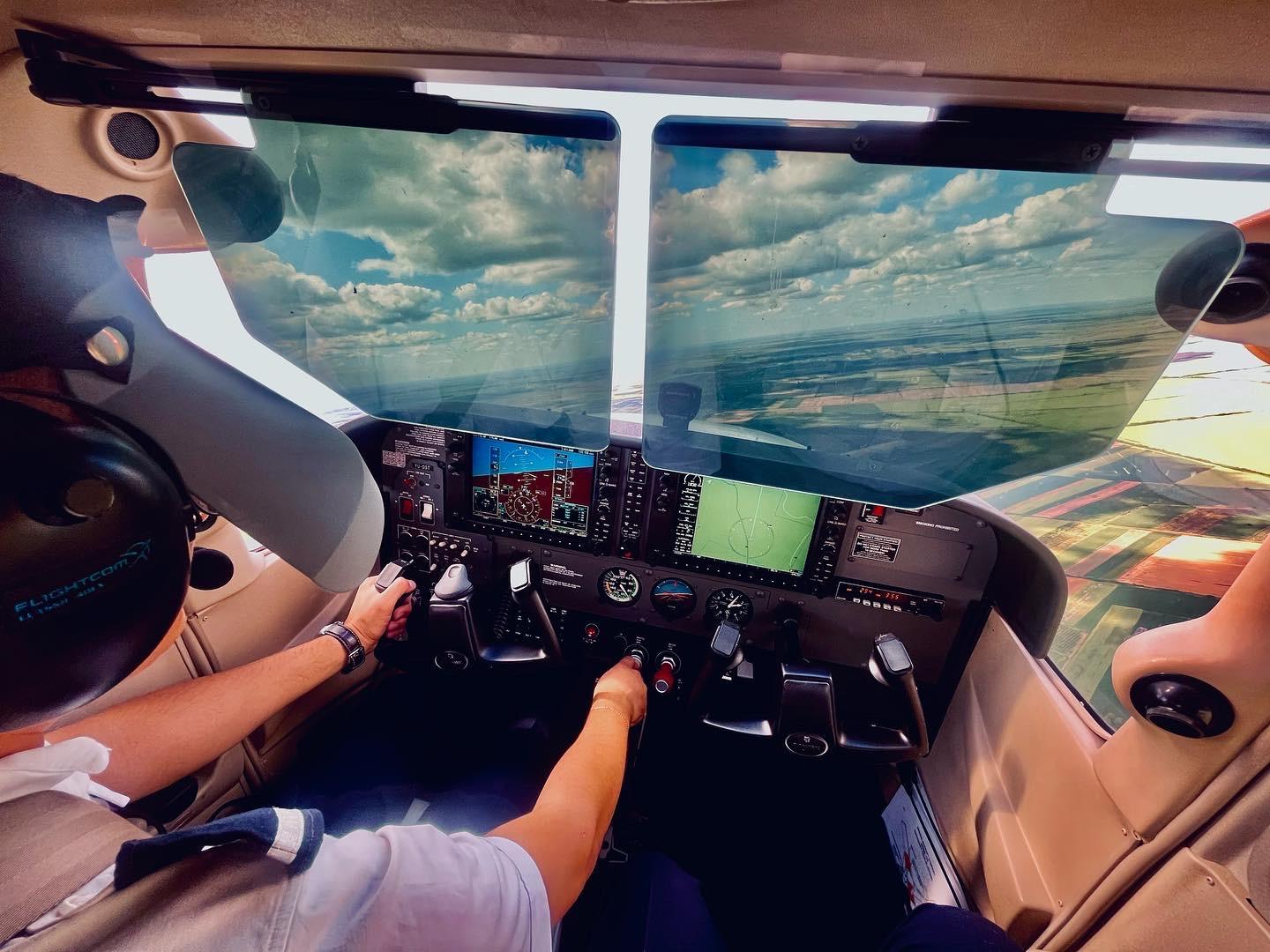 A person in a cockpit of a plane

Description automatically generated