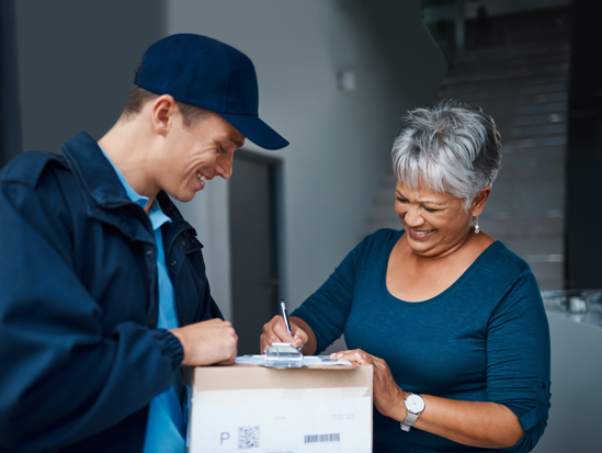 Mujer feliz al recibir en tiempo y forma una entrega, mientras firma de recibido al repartidor. 