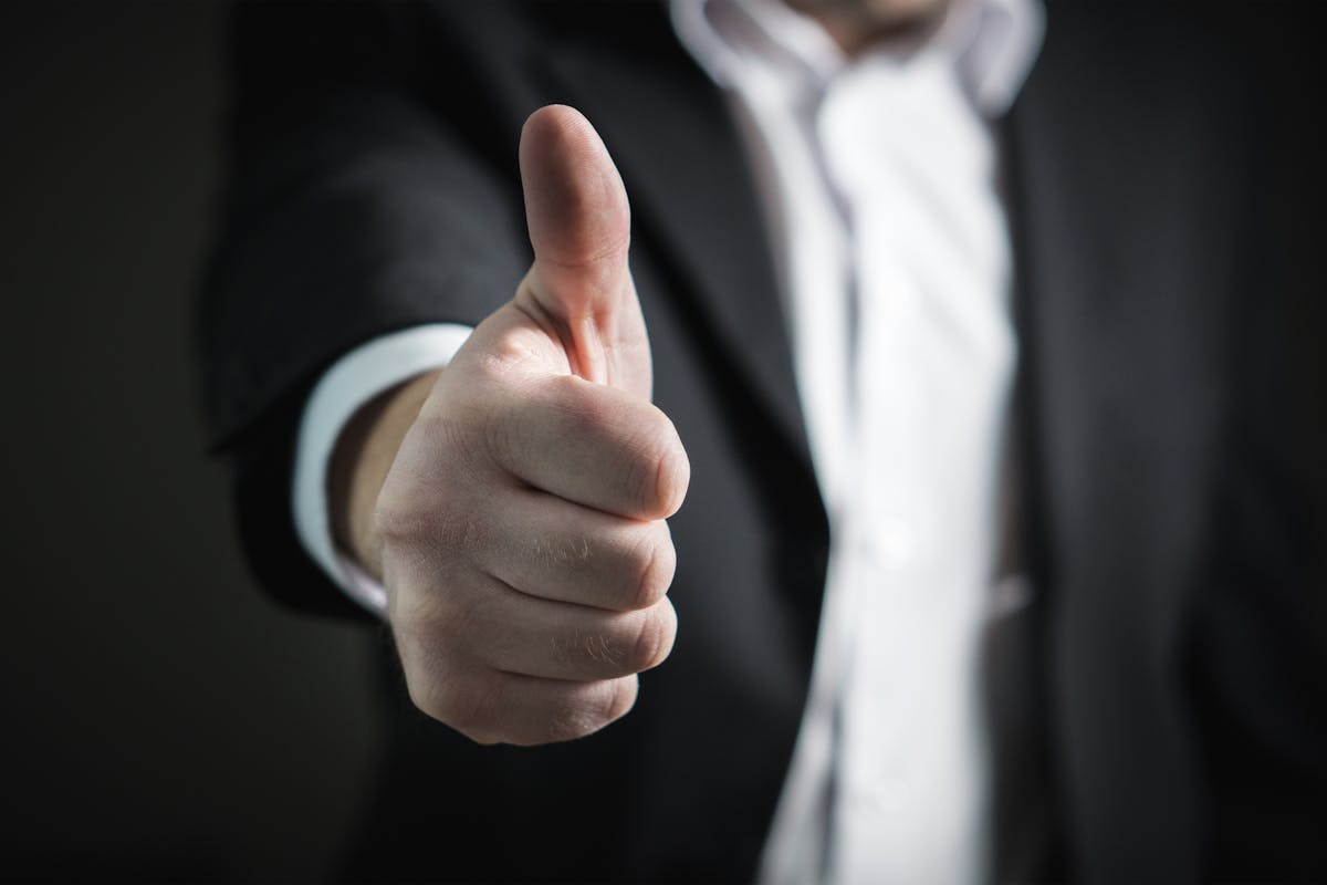 a person with his thumbs up showing positive approval