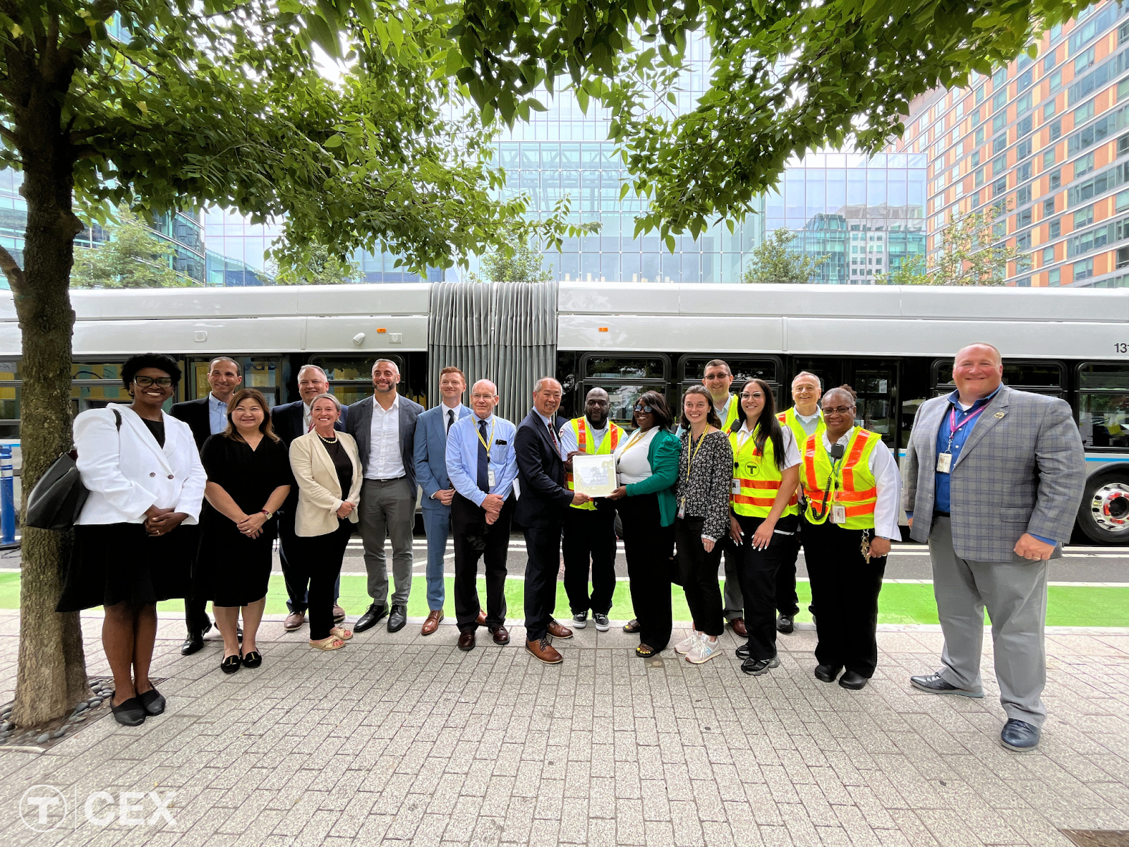 Seaport business leaders and MBTA employees gather in front of a Silver Line bus.