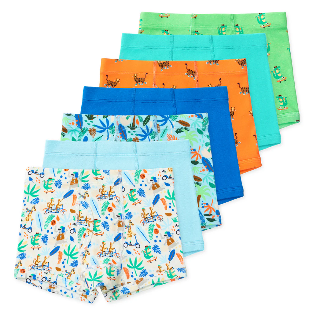 Six pairs of natural fiber kids' underwear in blue, orange, green, and teal with palm trees, giraffes, alligators, tigers, leaves, and blue feather patterns