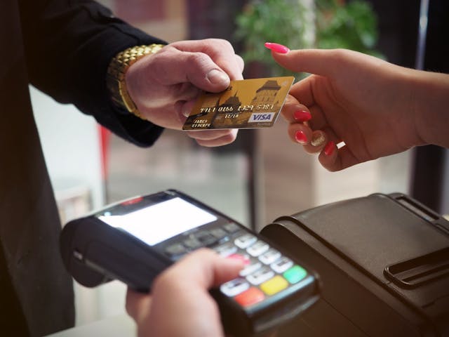 A man holding a credit card, ready to make a purchase. 