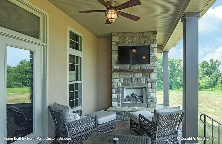 A stone fireplace topped with a TV completes the back porch.