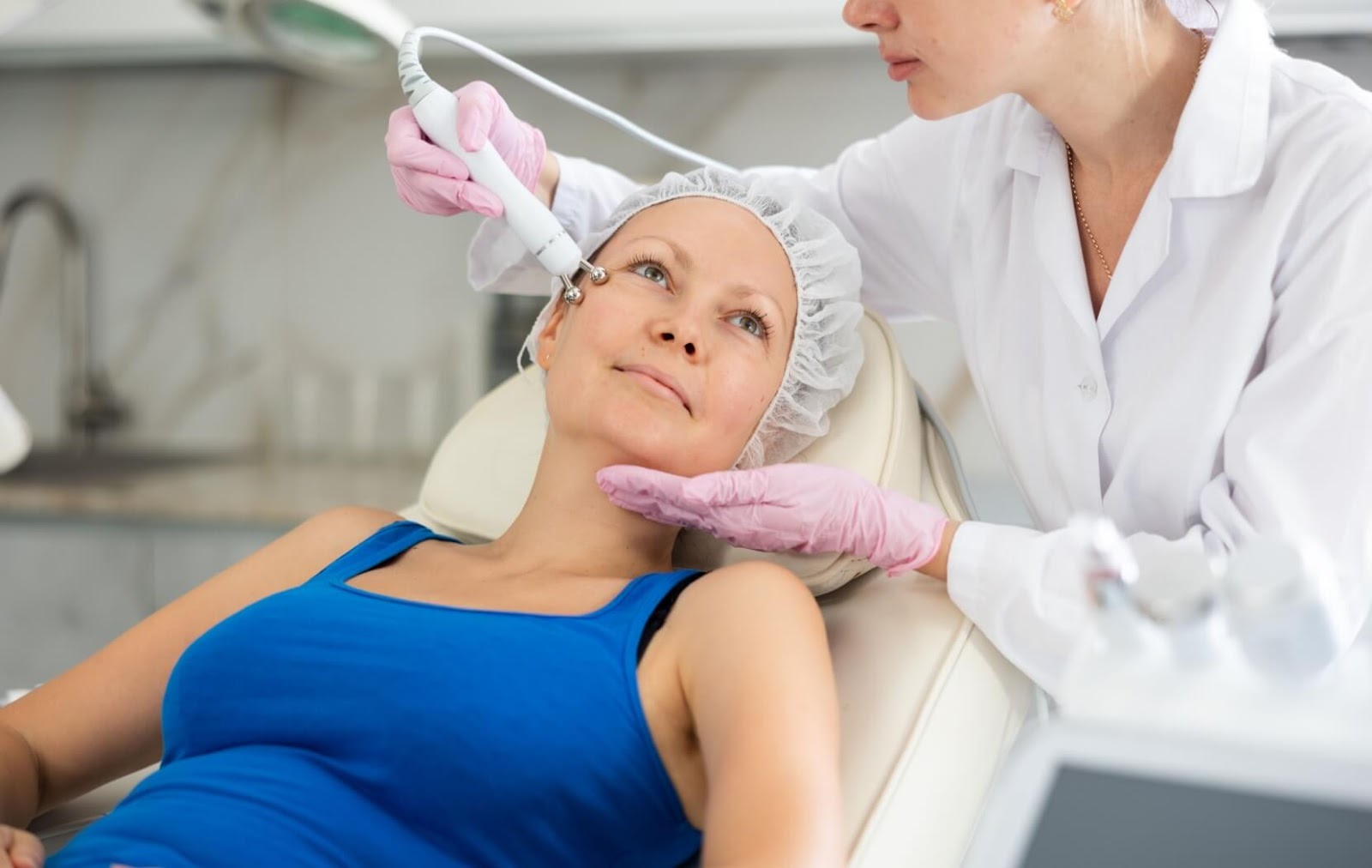 A technician uses aesthetic equipment to treat their client's under-eye bags and promote skin health.