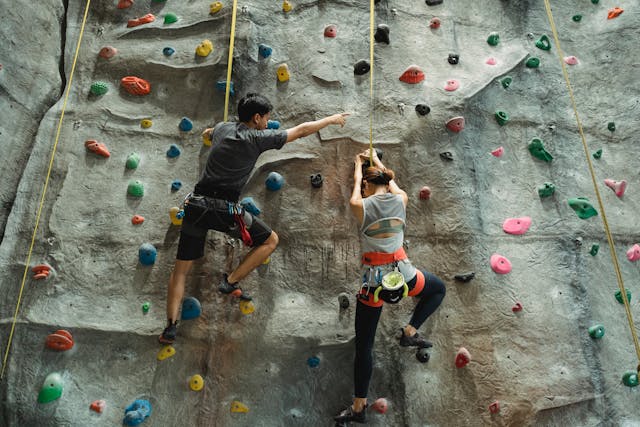 A woman and man evaluating the risks while rock climbing