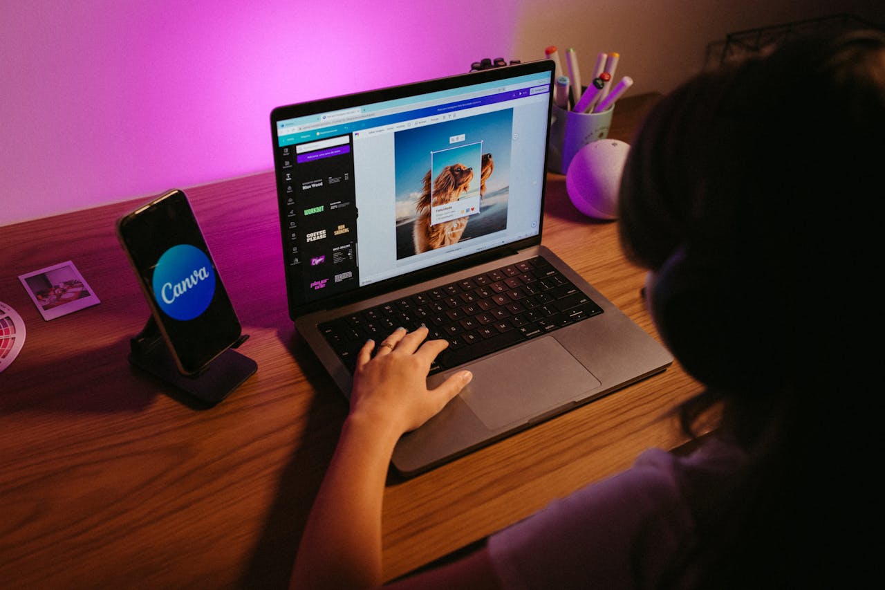 A person focused on a laptop glowing with a soft purple light, creating a cozy and techy atmosphere.