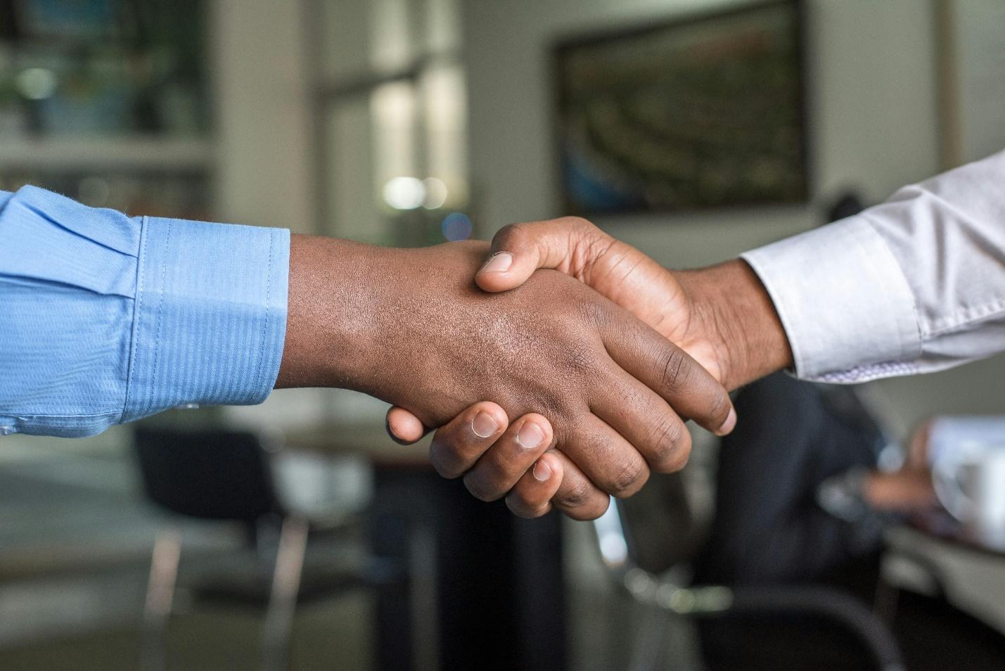 Free Close-up of two men's handshake symbolizing agreement in an office. Stock Photo
