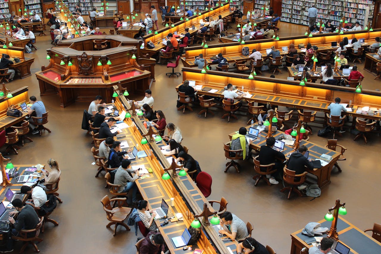 A bustling library with people studying at tables.