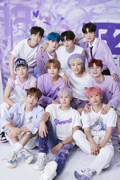 This containTHE BOYZ sitting next to each other in front of a purple wall