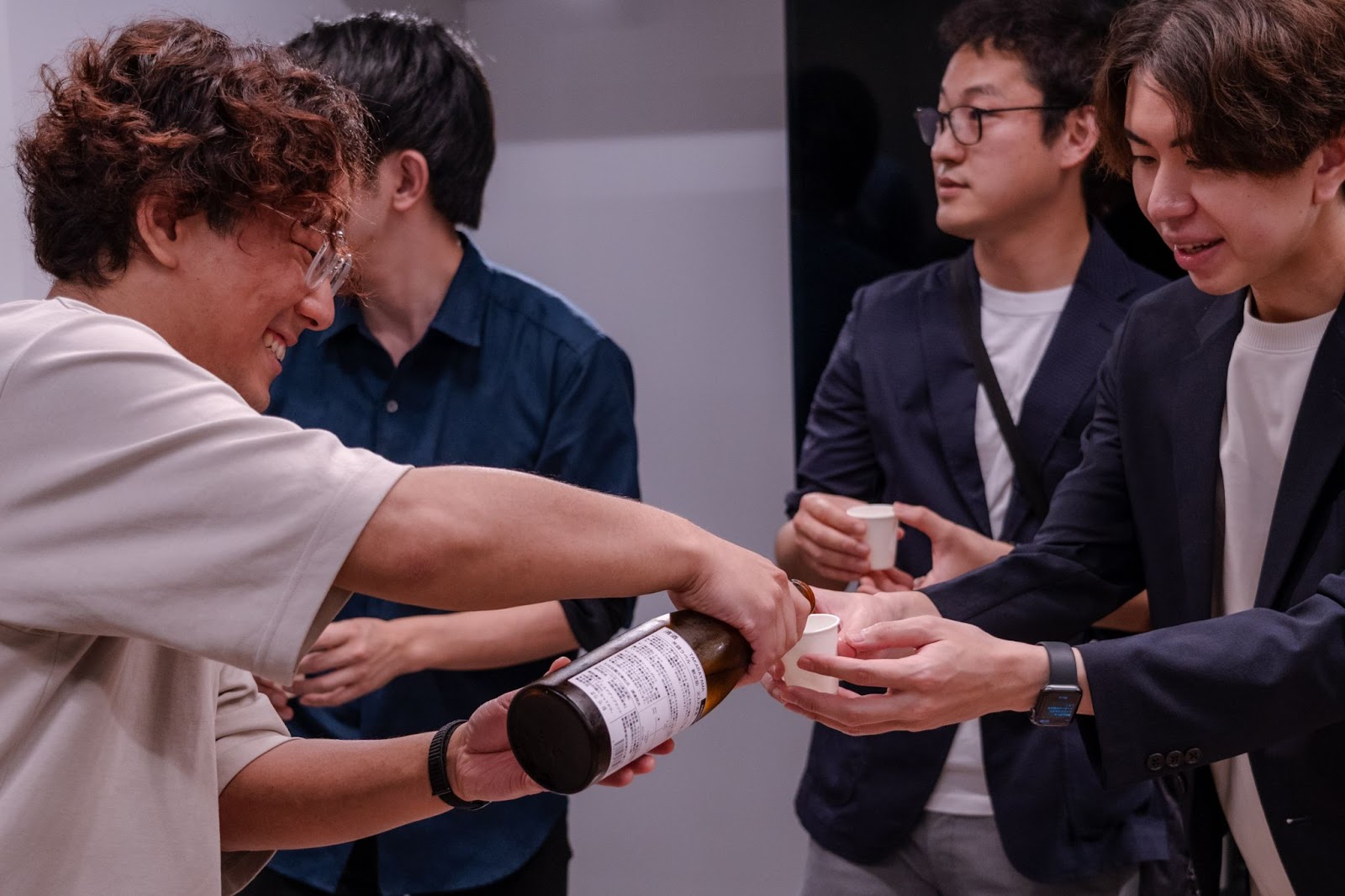 お互いにお酒を注いで打ち解ける、日本酒イベントの参加者たち