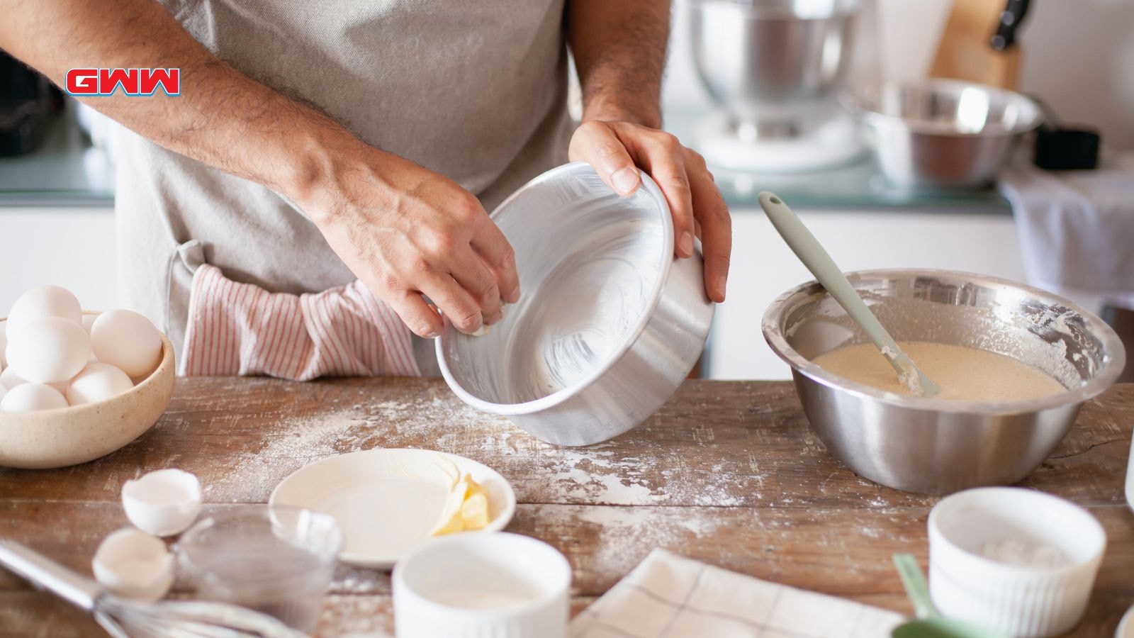 A person greasing a baking pan