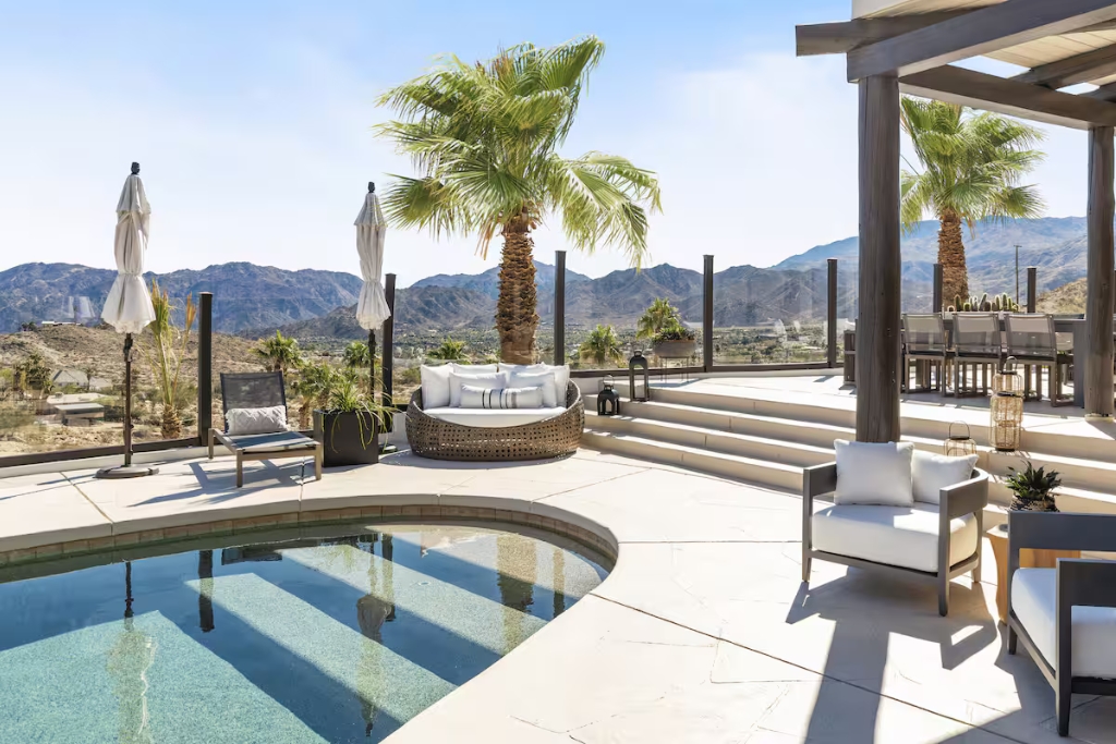 lounge chairs palm trees umbrellas blue pool and white concrete airbnb in palm desert