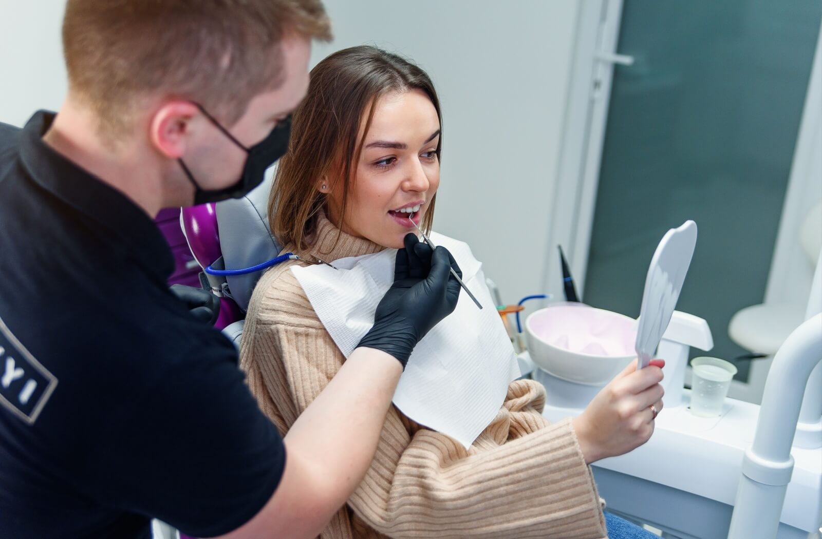 A person smiles as they look at their new dental implants and healthy smile.