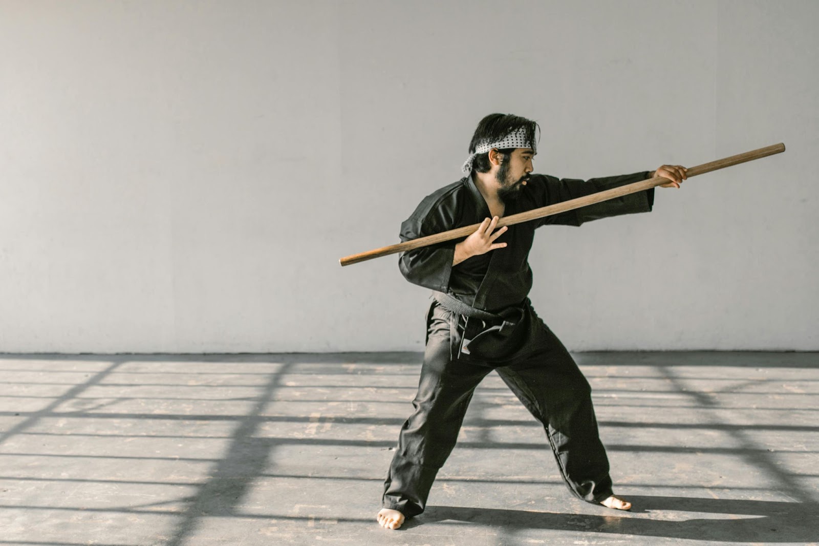 A martial arts instructor performing moves with a stick