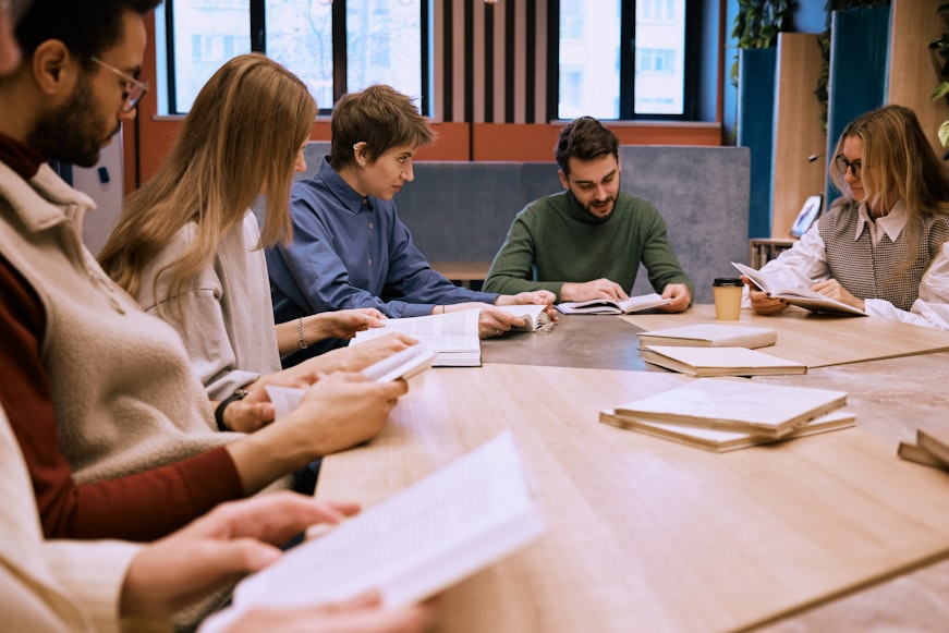 A group of people sitting around a wooden table