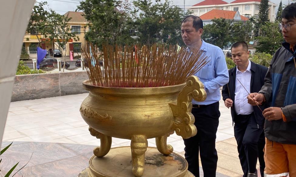 A group of men standing next to a large gold pot with sticksDescription automatically generated