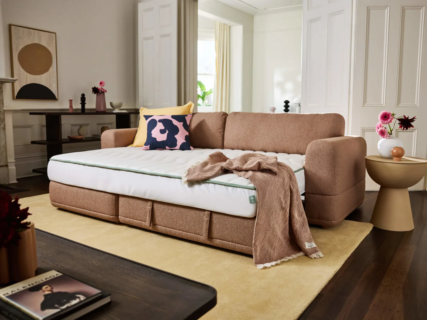 tan sofa bed with pink pillow and blanket