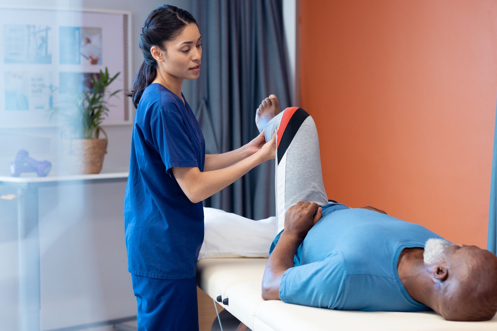 Man lying down on a table with a physical therapist.