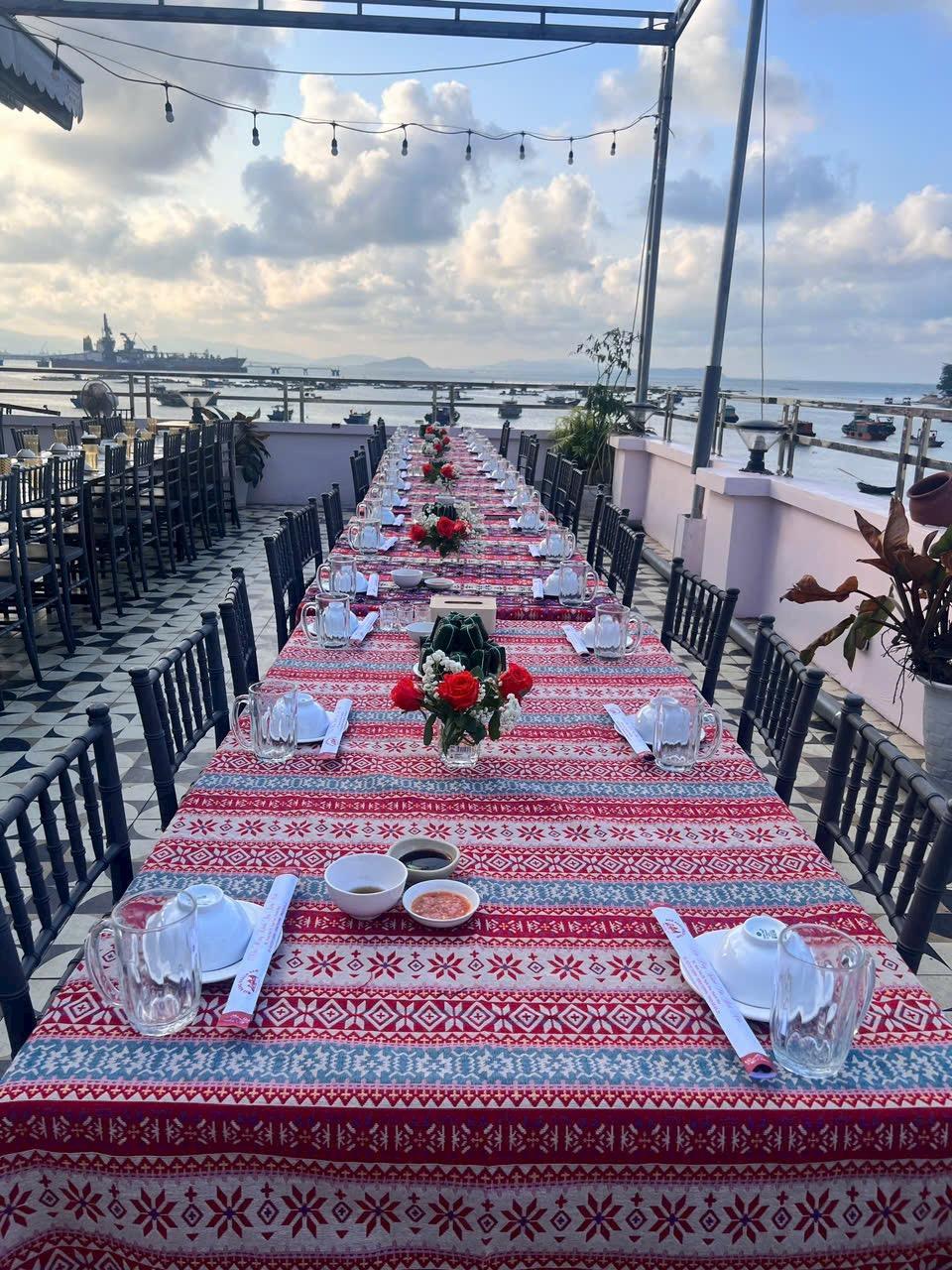 A long table set for a dinner

Description automatically generated