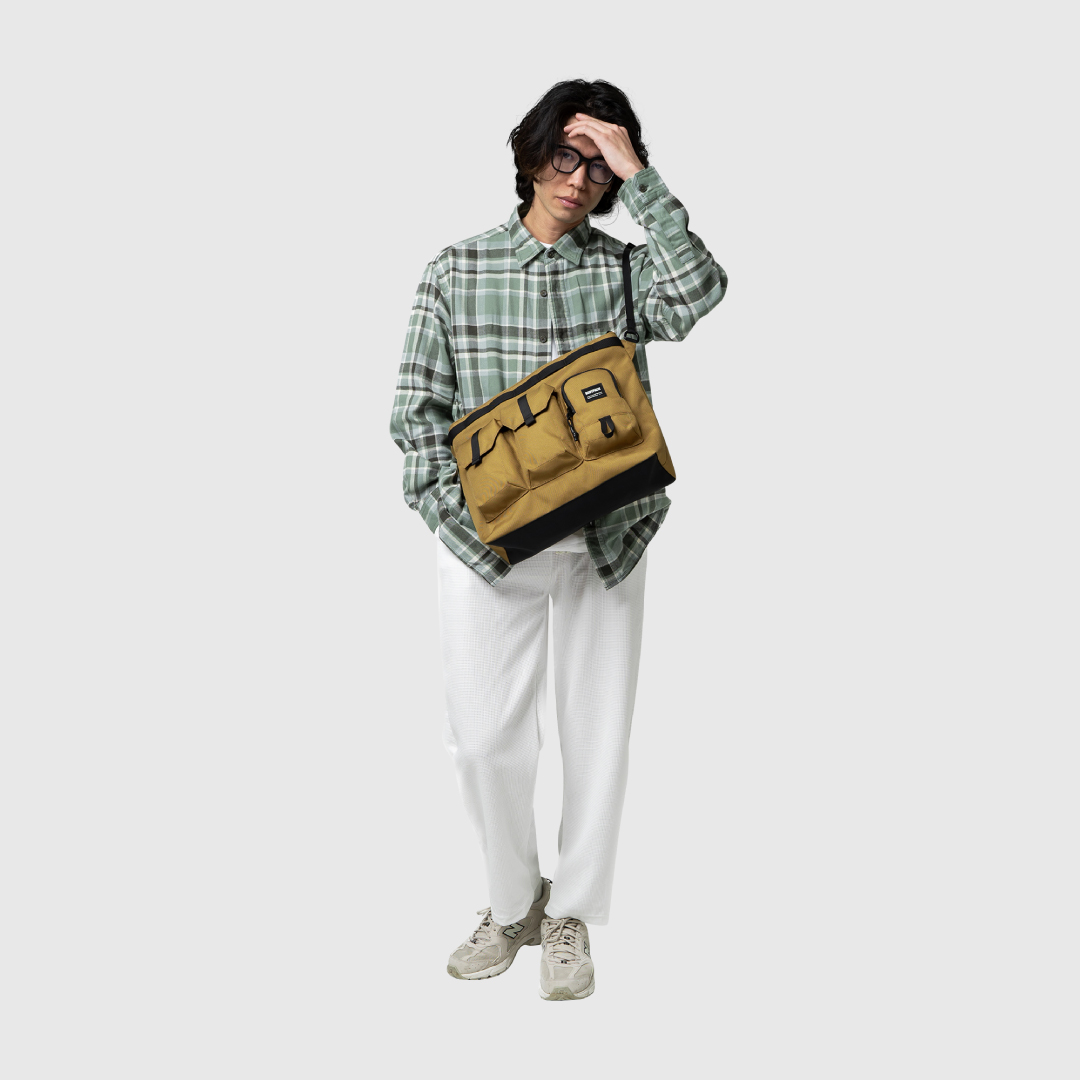 A man carries a sling bag for work