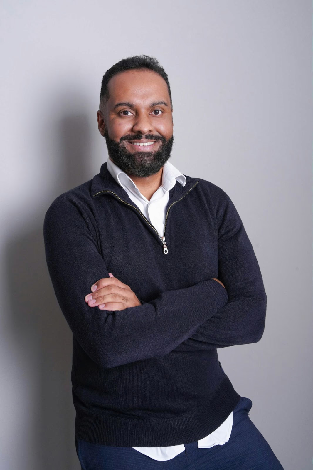 A man posing for his headshot against a solid headshot background