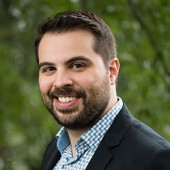 Portrait of Professor Alvarado smiling and wearing a suit