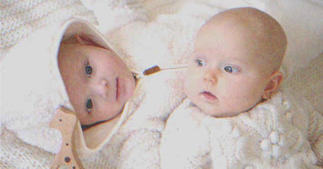 Two babies laying on a bed | Source: Shutterstock