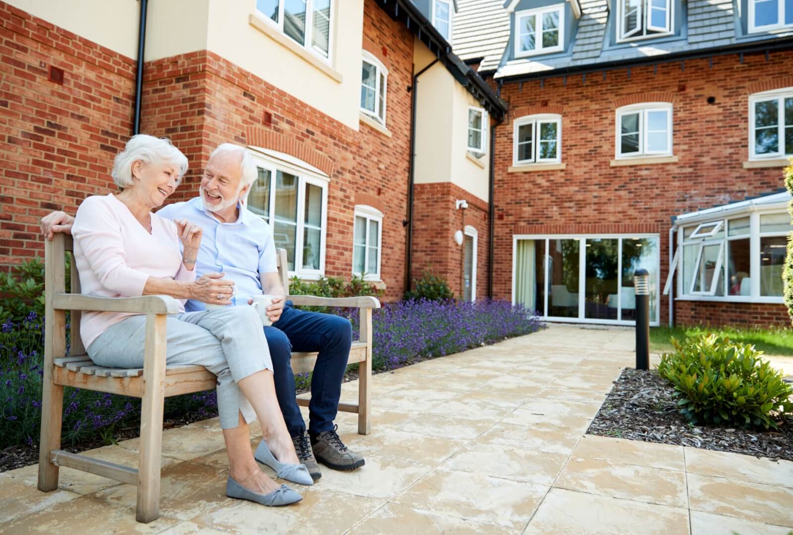 A retired couple enjoying sitting outside at an assisted living community