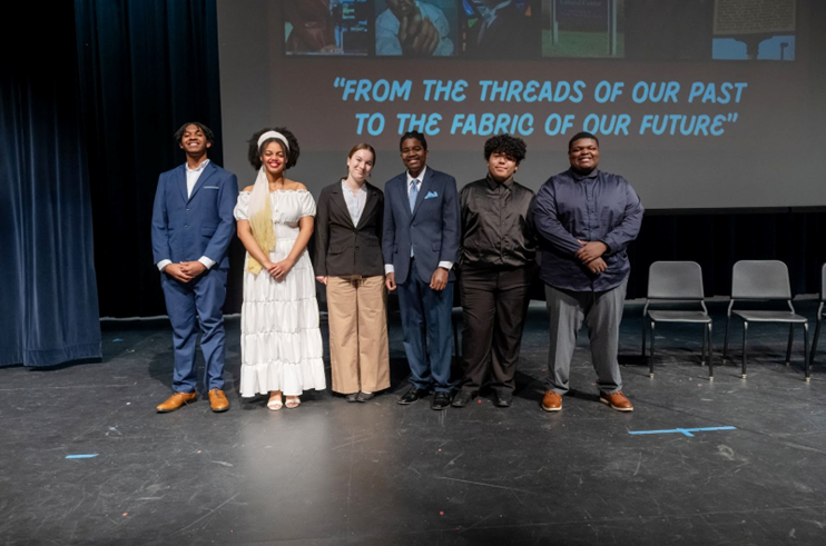 Group of students on stage at Woodson High School for a Black History Month celebration. 