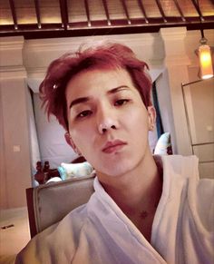 This contain Mino with red hair is taking a selfie in the mirror while wearing a robe