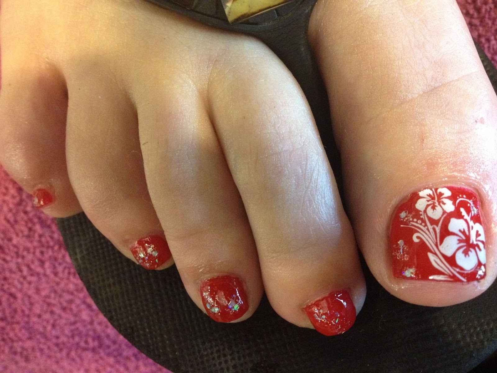 Close-up of toes with blooming hibiscus toe nail