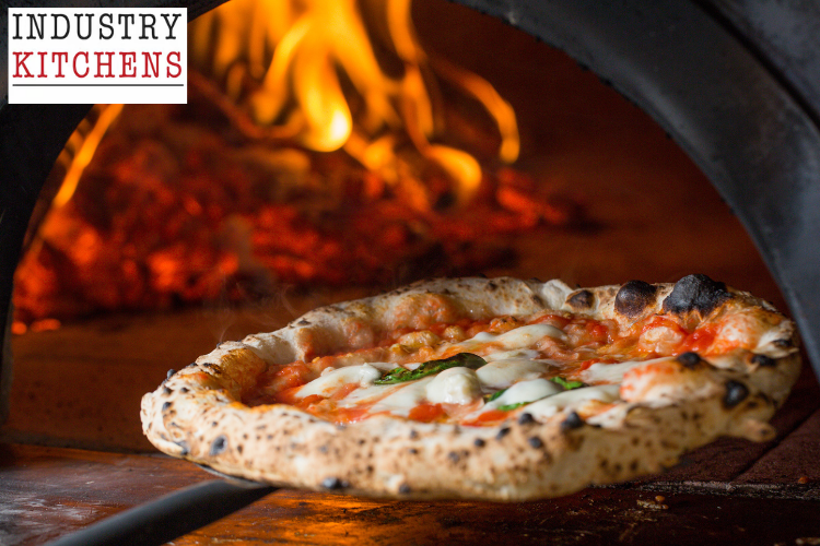 Close-up of pizza baking with visible flames in a wood-fired oven, showing ideal cooking environment