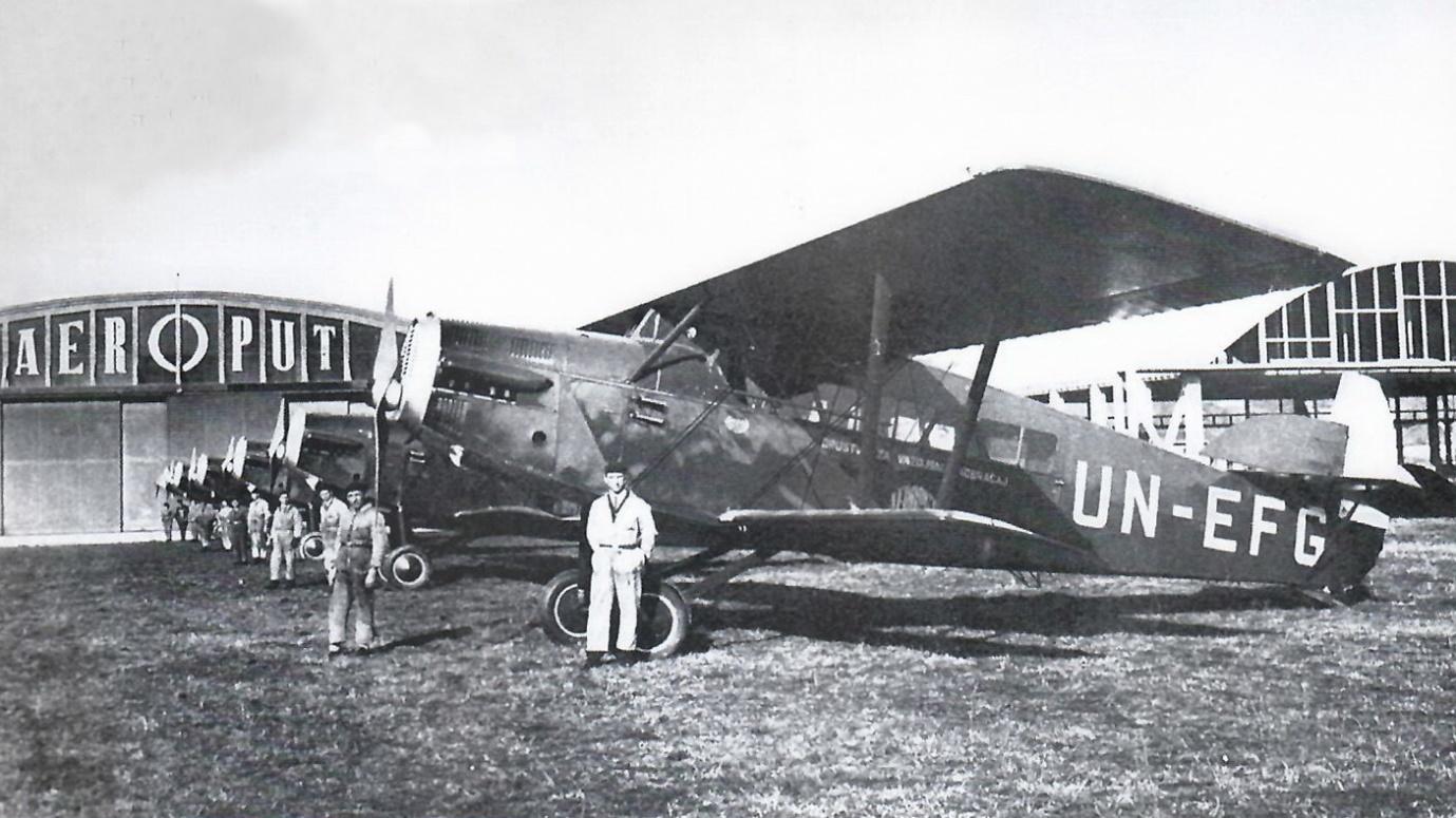 A group of men standing next to an airplane

Description automatically generated