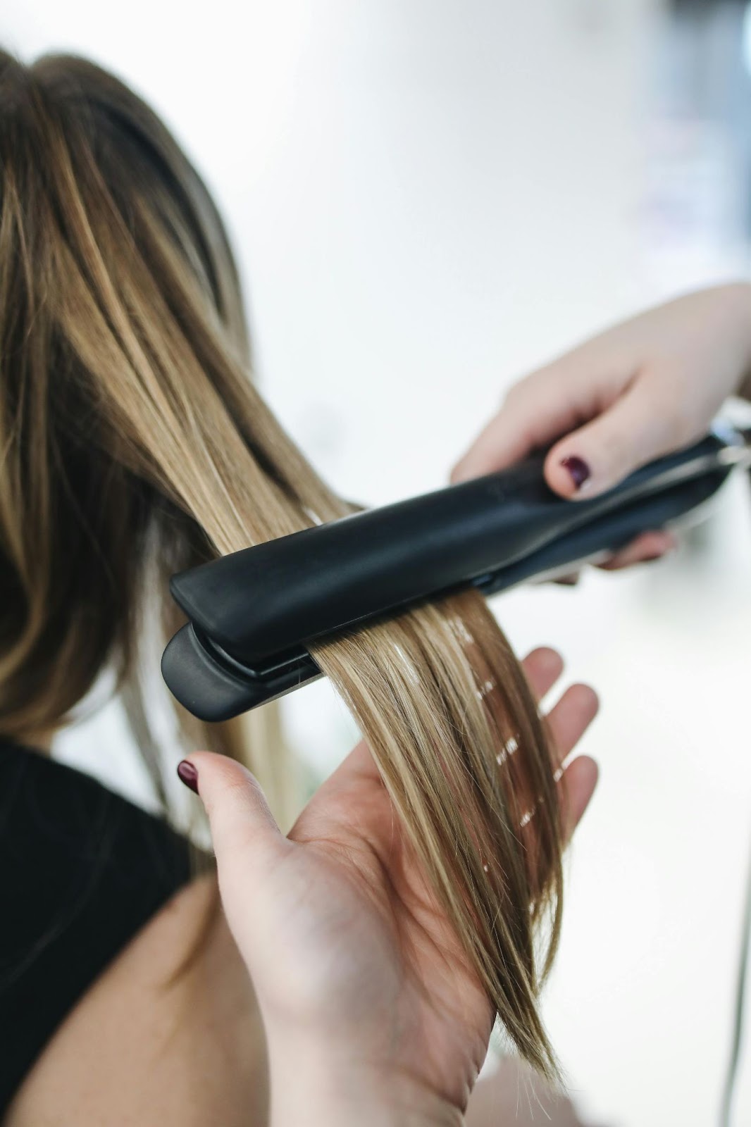 A woman getting her hair straightened