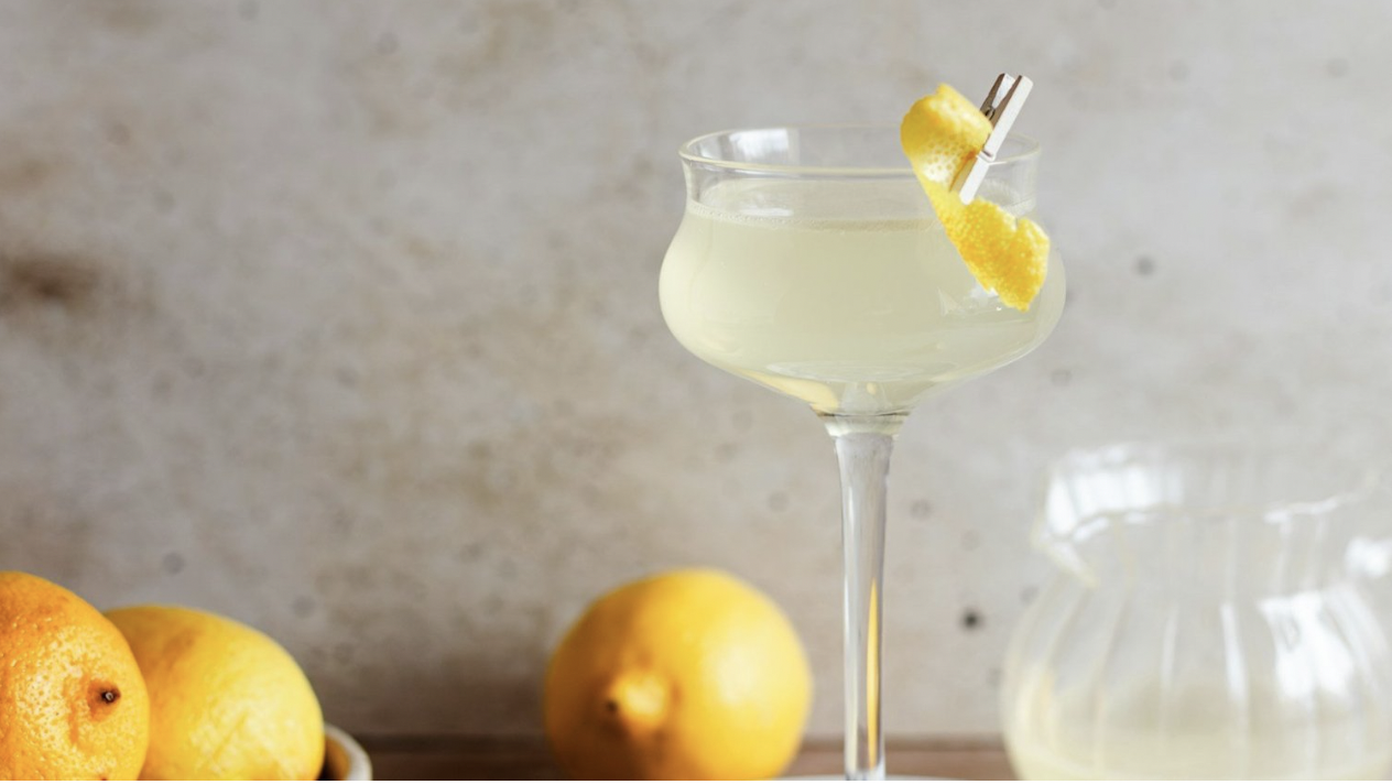 A French 75 is in a fancy glass with a lemon peel paperclipped to the side of the glass