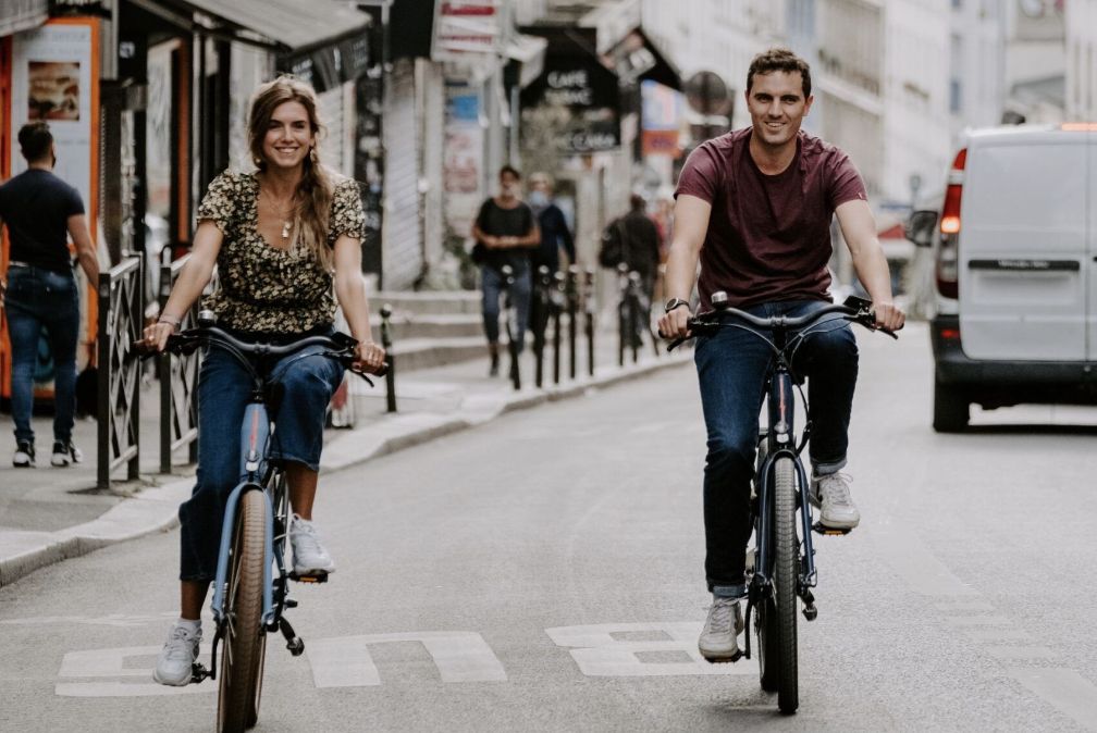 A couple strolling through Paris with their rented cargo bike