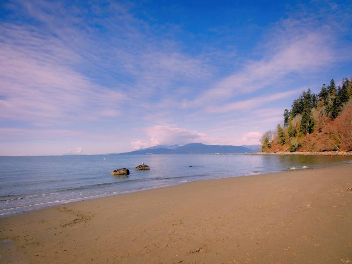 Wreck Beach, a sandy expanse with mountains visible across the water