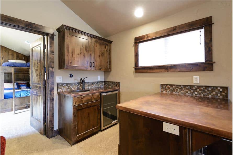 The bonus room includes wooden top counters, a sink, and a beverage fridge.