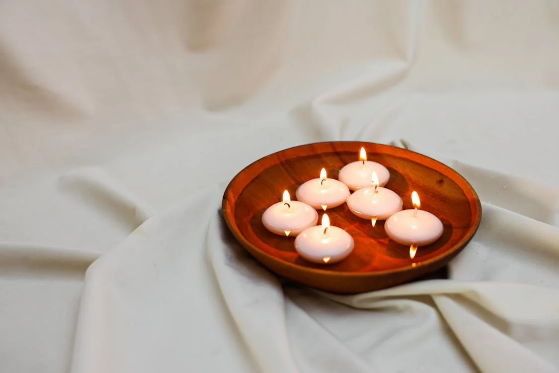 floating tea cup candles in a wooden tray