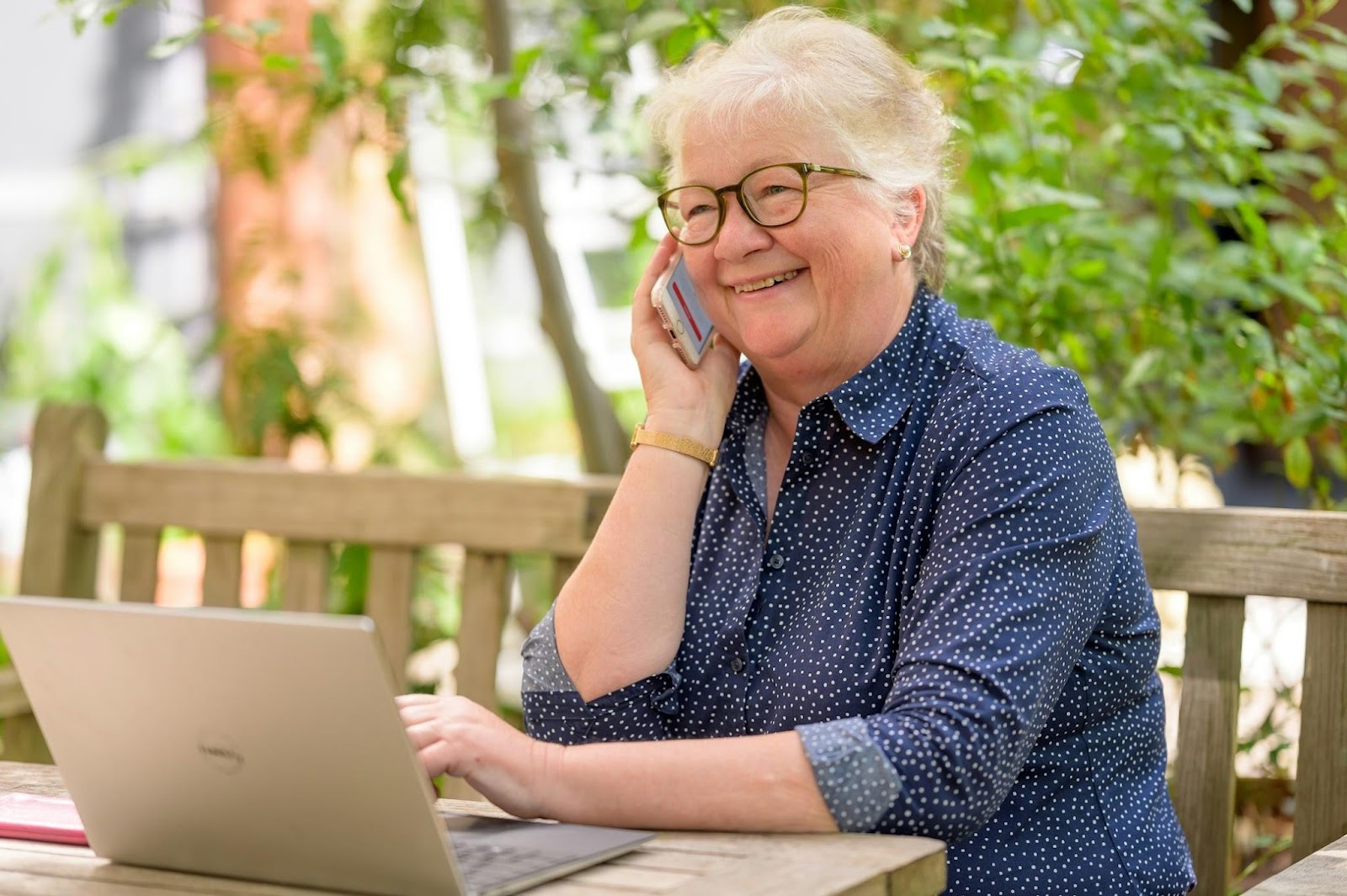 Mulher no celular usando um laptop