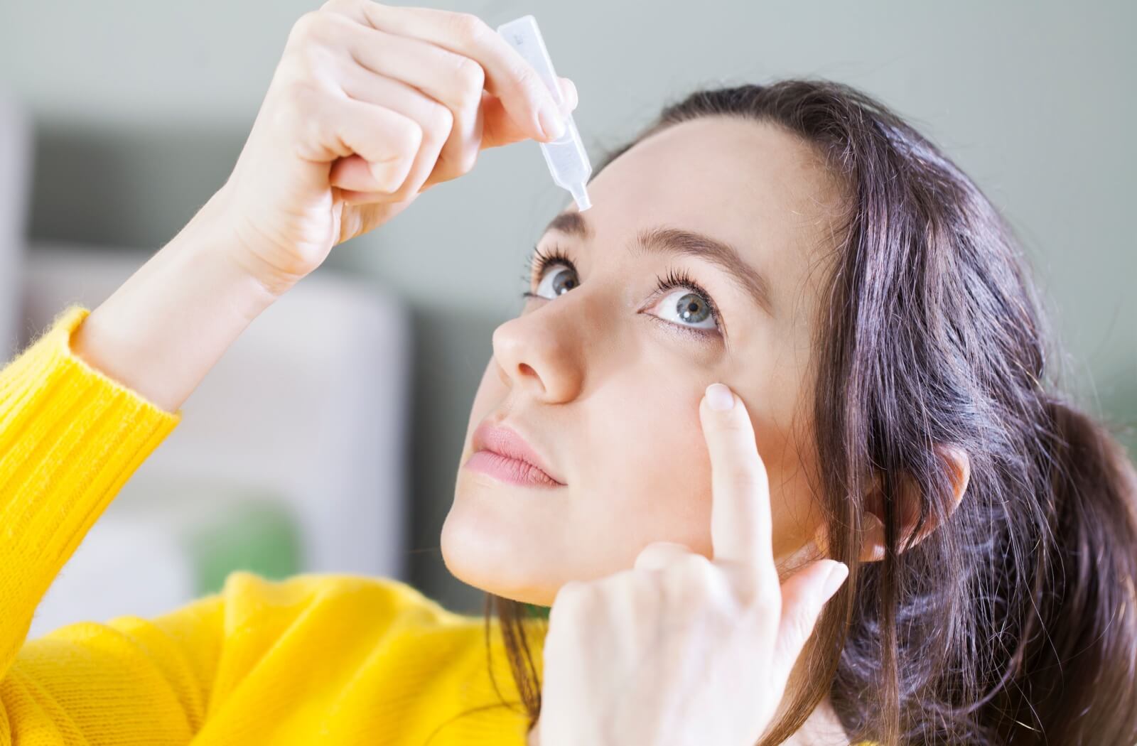 A contact lens wearer using contact lens safe eye drops to help with their dry eye symptoms
