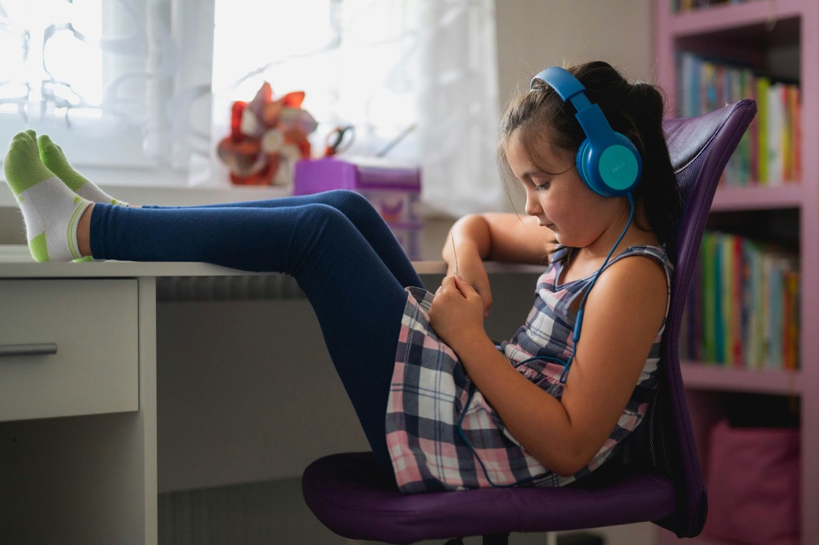 A girl listening to a podcast whilst in her at home classroom