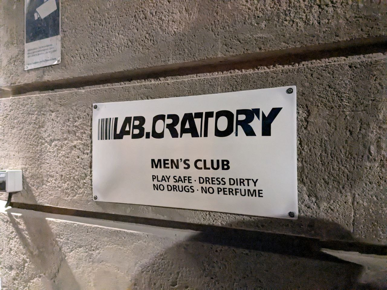 sign on the wall in Berghain pointing patrons to gay hookup club in berlin Lab.oratory