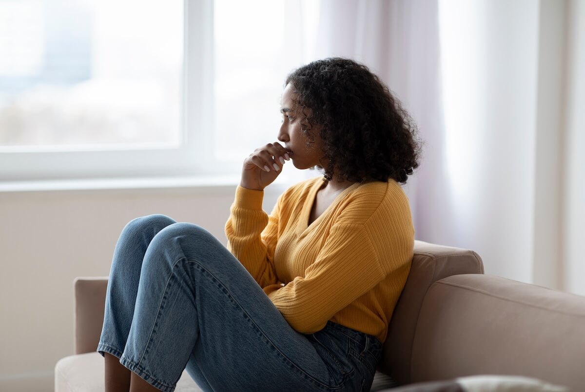 Bereavement leave policy: sad woman sitting on a couch