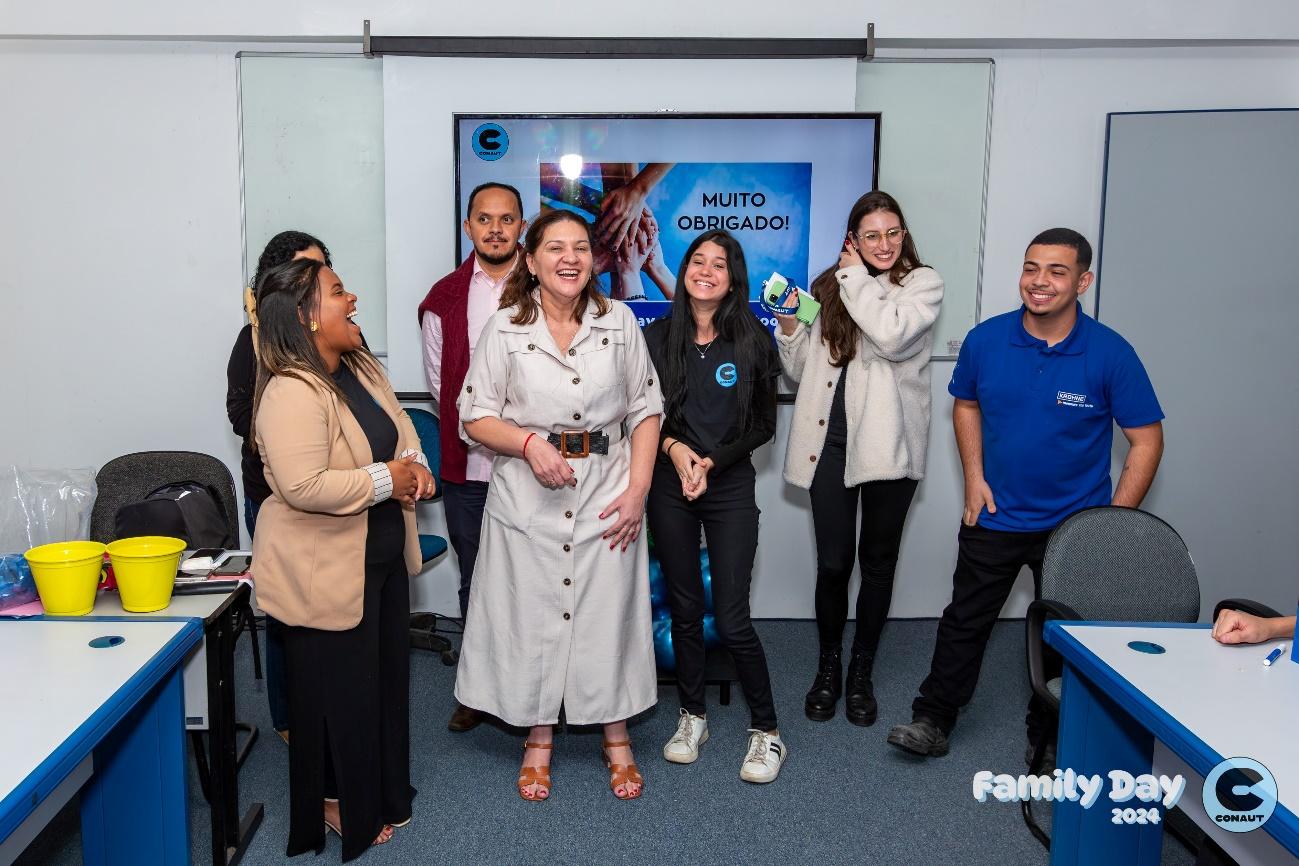 Grupo de pessoas posando para foto em frente a parede azul

Descrição gerada automaticamente com confiança média