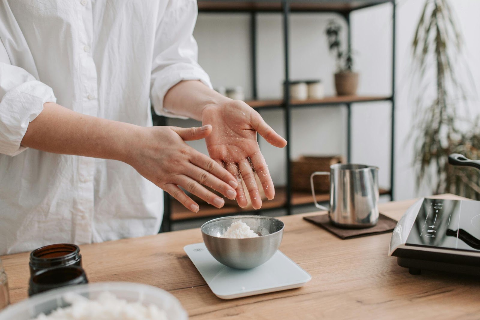 A person weighing ingredients in a steel bowl